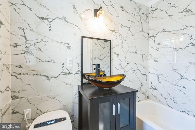 bathroom with vanity, toilet, and a tub