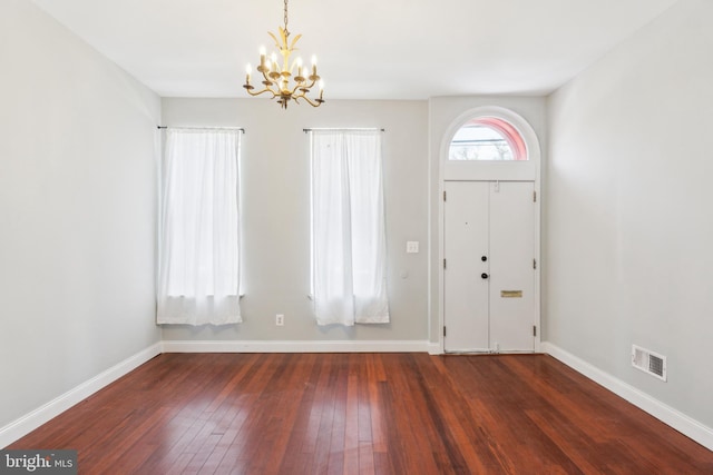 foyer featuring dark wood-type flooring and a notable chandelier