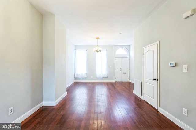 interior space featuring dark wood-type flooring and a notable chandelier