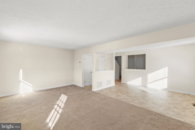 carpeted empty room with a textured ceiling