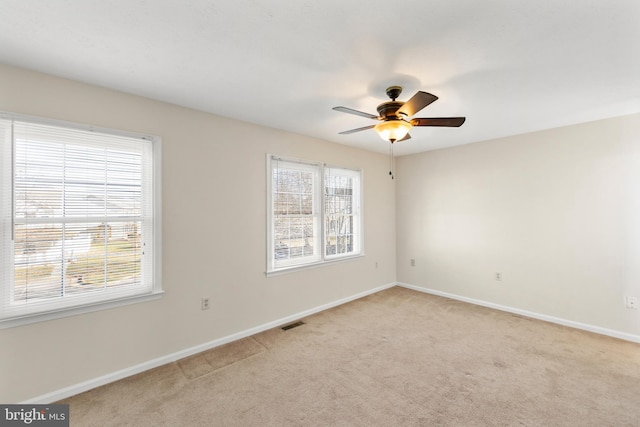 spare room with ceiling fan and light colored carpet