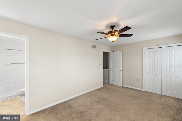 unfurnished bedroom featuring connected bathroom, ceiling fan, and light carpet