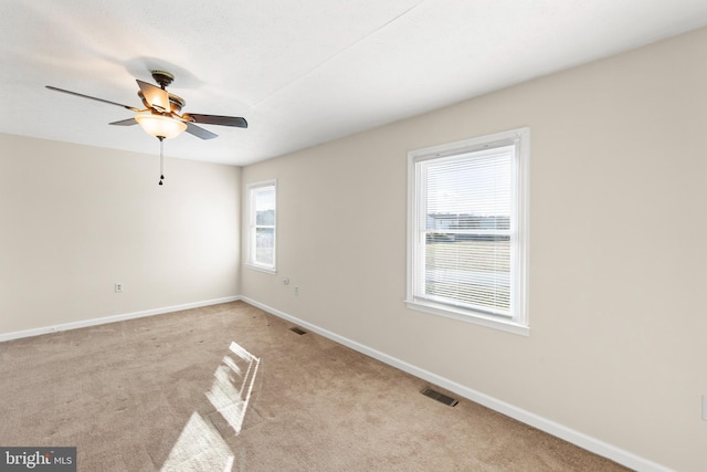 spare room with ceiling fan and light colored carpet