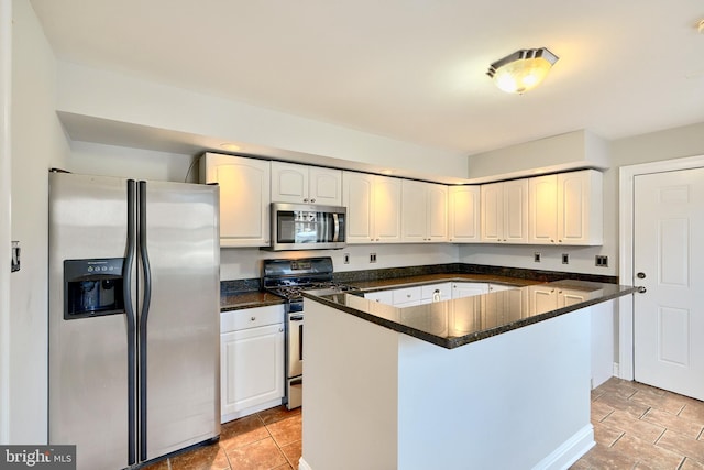 kitchen with dark stone countertops, white cabinetry, and stainless steel appliances