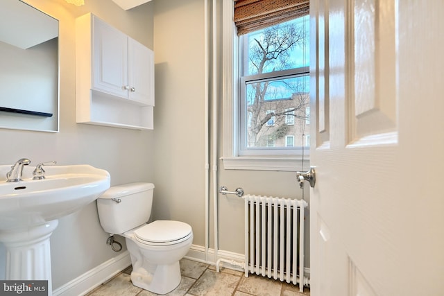 bathroom with toilet, radiator, and sink