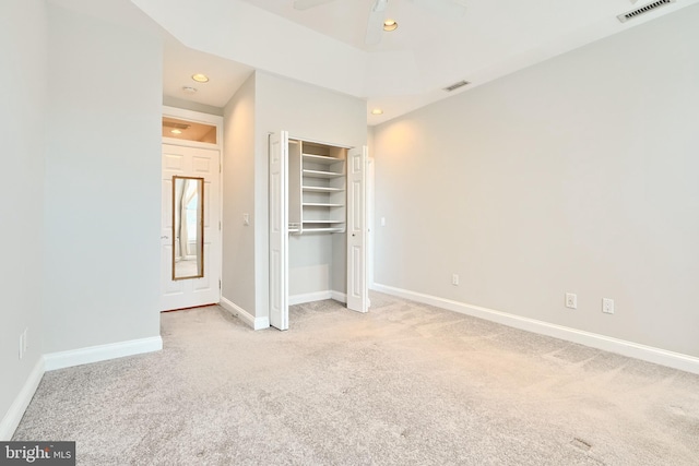 unfurnished bedroom featuring light carpet and a closet