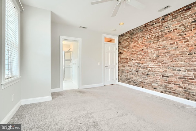 unfurnished bedroom featuring ceiling fan, carpet, and brick wall