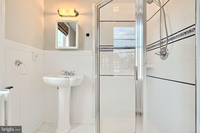 bathroom with tile patterned floors and a shower with door