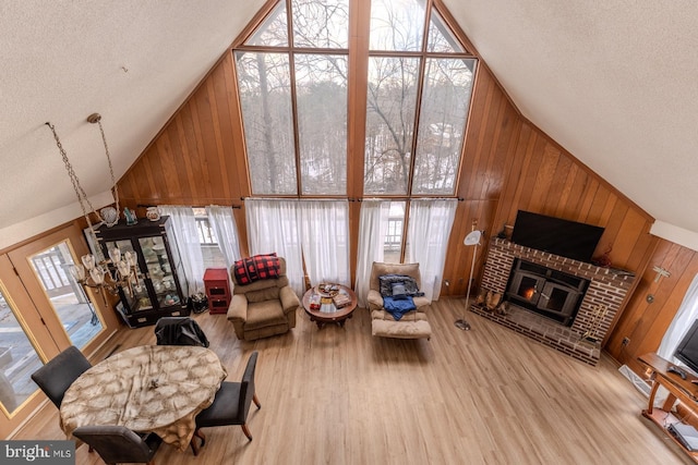 living room featuring high vaulted ceiling, light hardwood / wood-style floors, and a healthy amount of sunlight