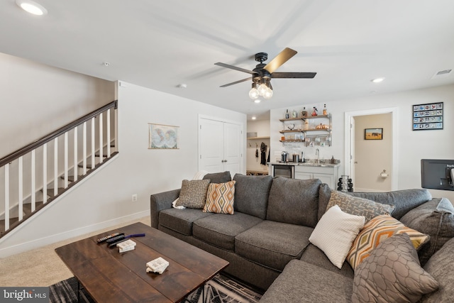 living room featuring carpet floors, indoor wet bar, and ceiling fan