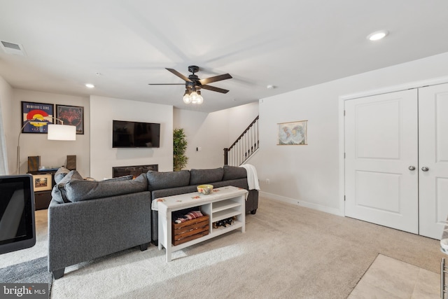 carpeted living room with ceiling fan