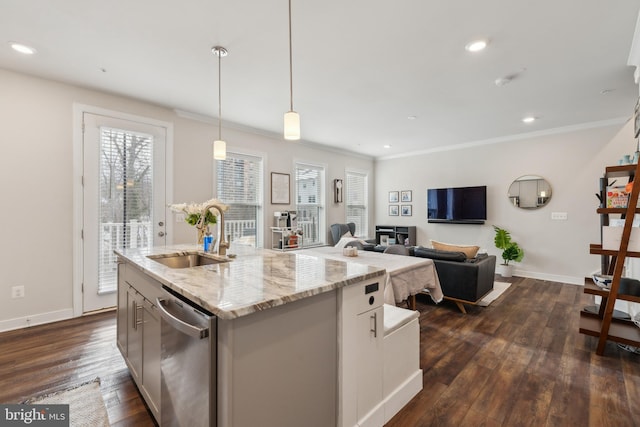 kitchen featuring light stone countertops, dishwasher, sink, pendant lighting, and a center island with sink