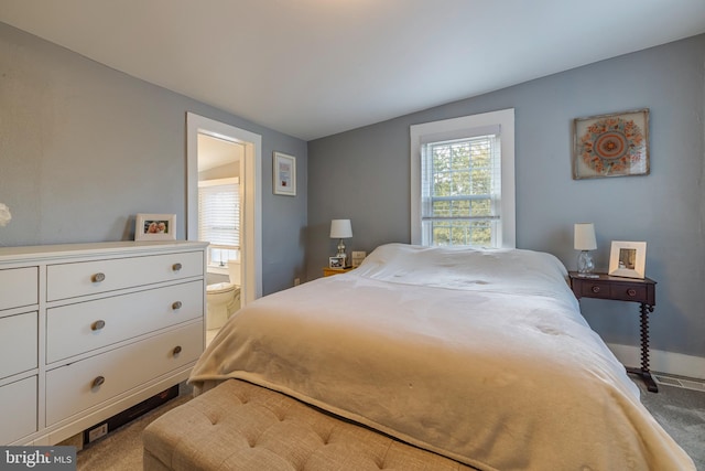 bedroom featuring carpet flooring, vaulted ceiling, and ensuite bath