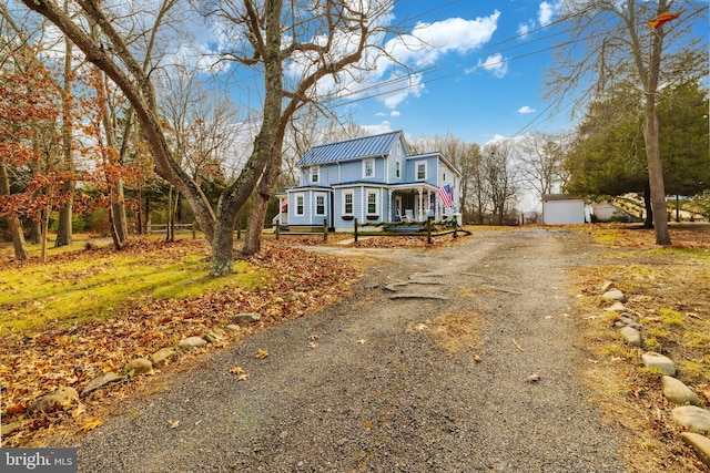 view of front of property with covered porch, an outdoor structure, and a garage