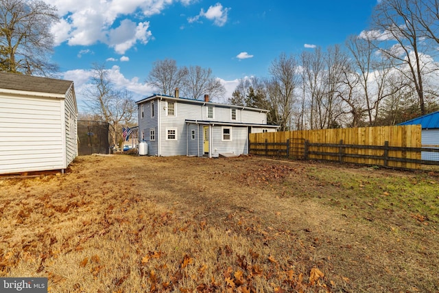 rear view of property featuring a storage unit