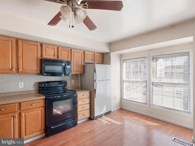 kitchen with visible vents, black appliances, light countertops, and decorative backsplash