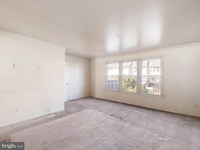 carpeted empty room featuring baseboards and ornamental molding