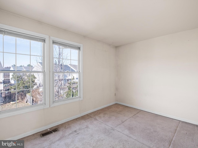 carpeted empty room featuring visible vents and baseboards