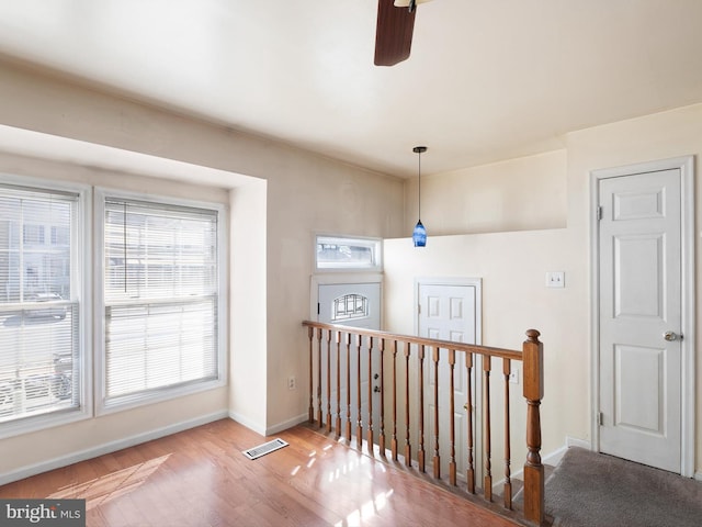 interior space featuring visible vents, baseboards, wood finished floors, and a ceiling fan