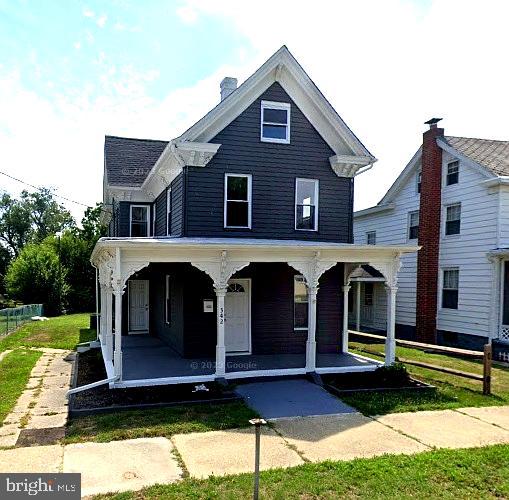 view of front of house featuring fence and covered porch