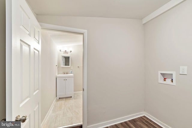 clothes washing area with laundry area, baseboards, washer hookup, and wood finished floors