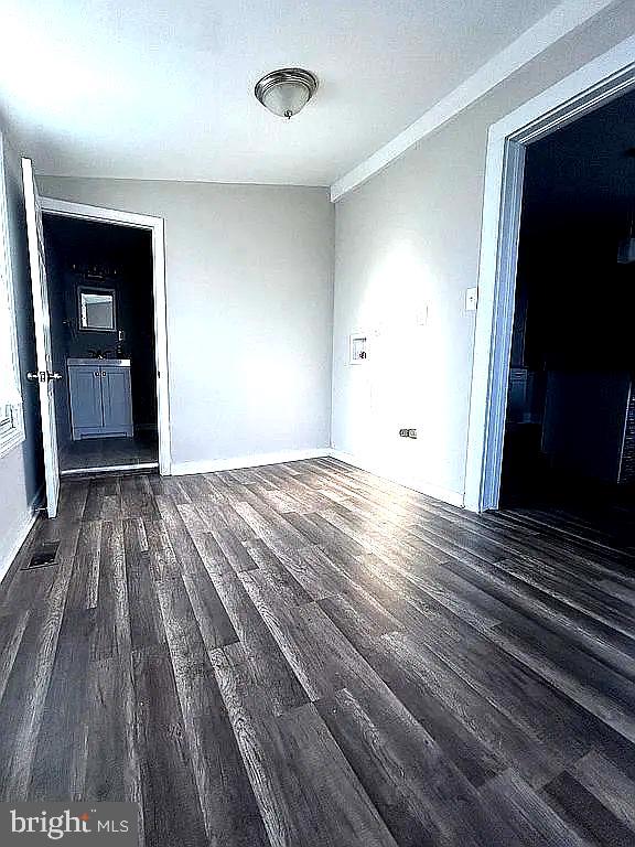 empty room with dark hardwood / wood-style floors, crown molding, and a textured ceiling