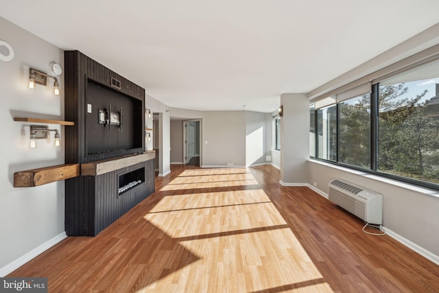 living room with a wall unit AC and wood-type flooring