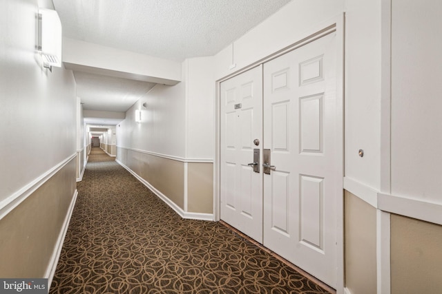 hall with a textured ceiling