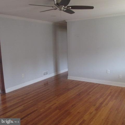 spare room with dark wood-type flooring, ceiling fan, and ornamental molding