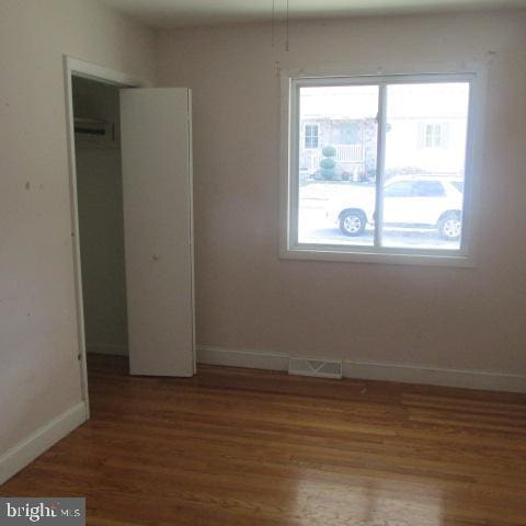 unfurnished bedroom with hardwood / wood-style flooring and a closet