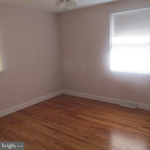 spare room featuring ceiling fan and dark wood-type flooring