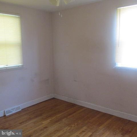 unfurnished room with hardwood / wood-style floors and a healthy amount of sunlight