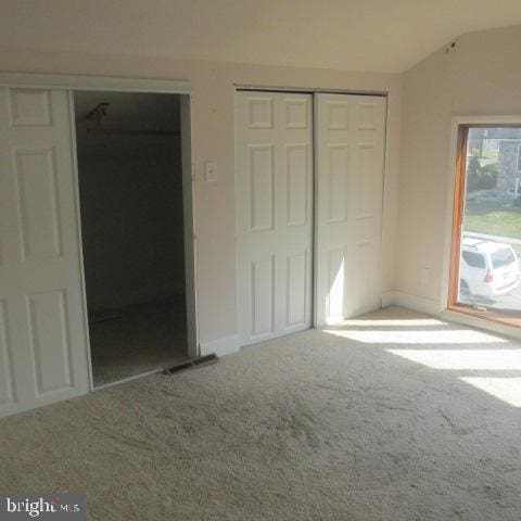 unfurnished bedroom with lofted ceiling and carpet floors