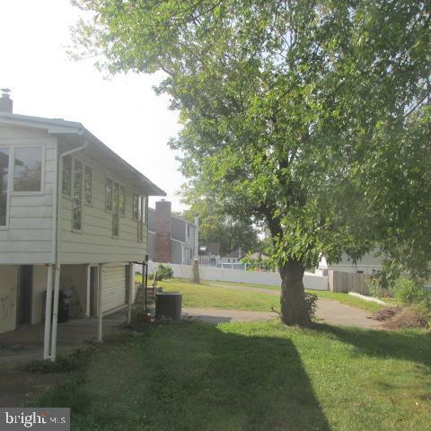 view of yard featuring a garage and central AC