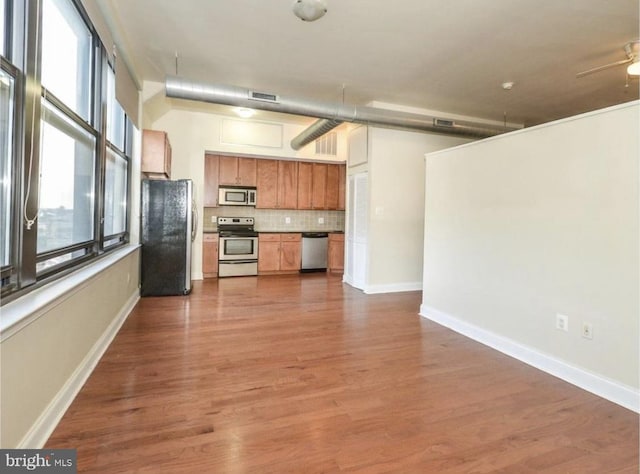 kitchen with backsplash, stainless steel appliances, and dark wood-type flooring