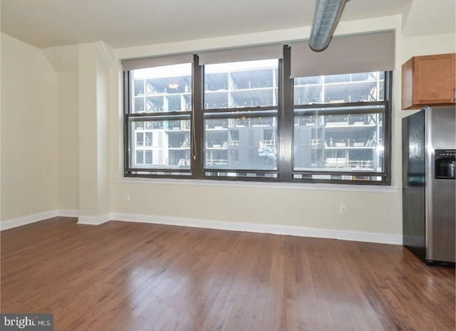 interior space with stainless steel fridge with ice dispenser and dark wood-type flooring