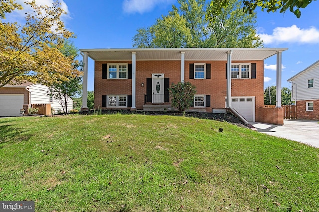 raised ranch with a front lawn and a garage