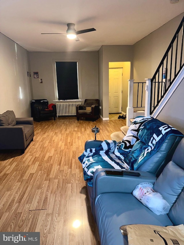 living room with radiator, ceiling fan, and hardwood / wood-style floors