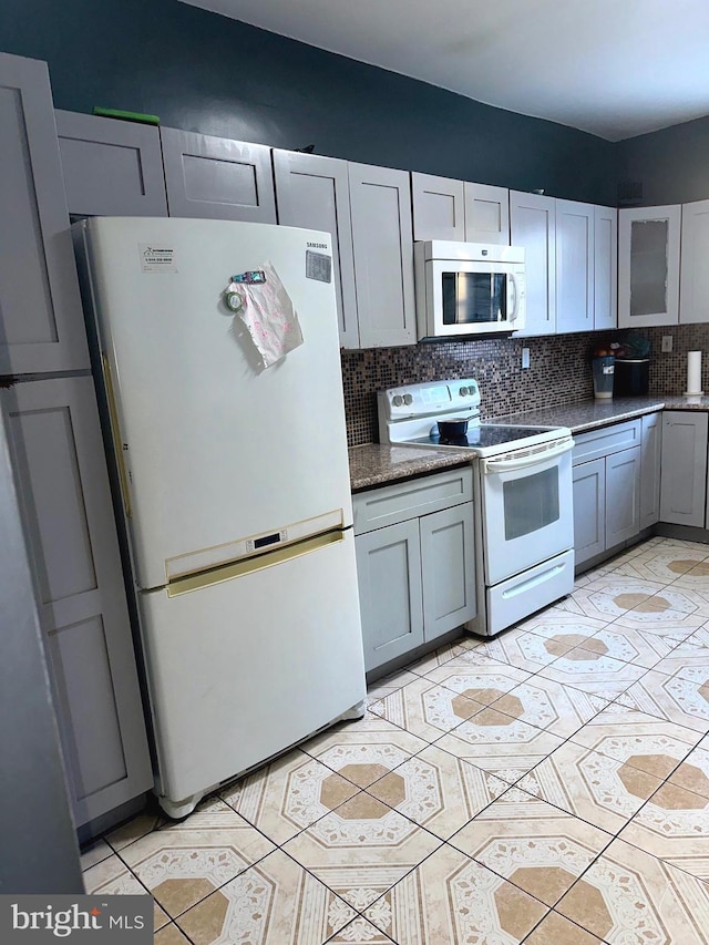 kitchen with gray cabinets, decorative backsplash, and white appliances