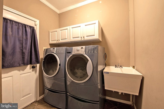 laundry room featuring cabinets, ornamental molding, dark tile patterned floors, sink, and washer and dryer