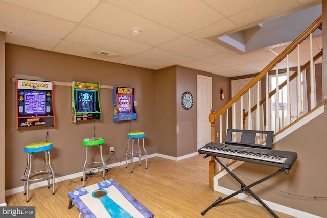 game room featuring a drop ceiling and wood-type flooring