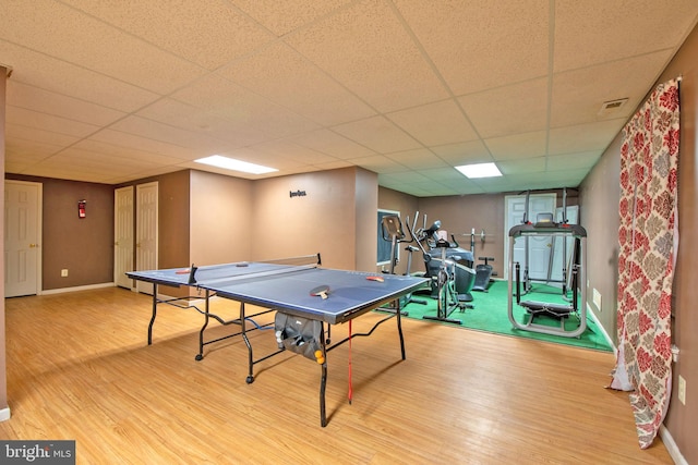 rec room with hardwood / wood-style floors and a paneled ceiling