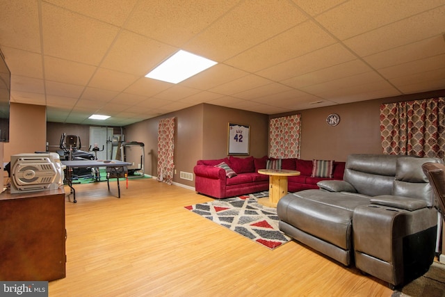 living room featuring hardwood / wood-style floors and a drop ceiling