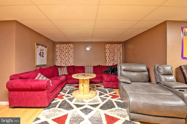 living room featuring wood-type flooring and a drop ceiling