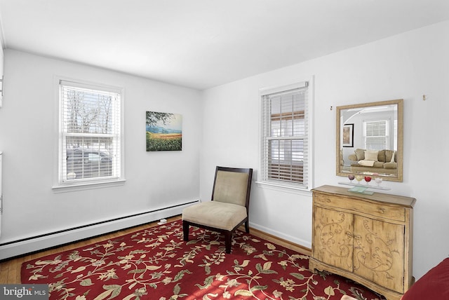 living area with hardwood / wood-style floors and baseboard heating