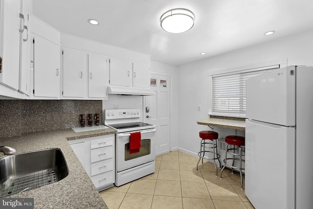 kitchen with custom range hood, white appliances, sink, light tile patterned floors, and white cabinets