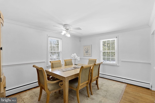 dining area featuring plenty of natural light, crown molding, and baseboard heating