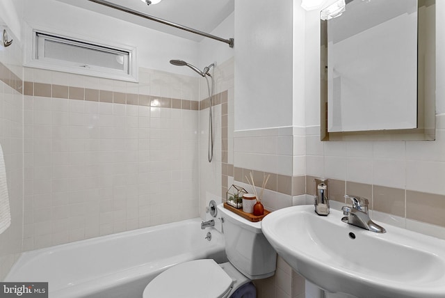 full bathroom featuring sink, backsplash, toilet, tile walls, and tiled shower / bath