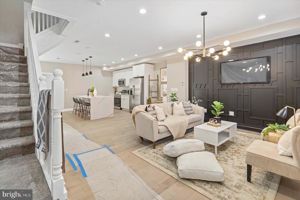 living room featuring light hardwood / wood-style floors and a notable chandelier