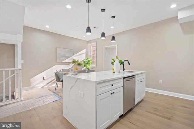 kitchen featuring white cabinetry, an island with sink, dishwasher, hanging light fixtures, and light stone counters